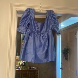 A blue satin blouse with puff sleeves and a square neck